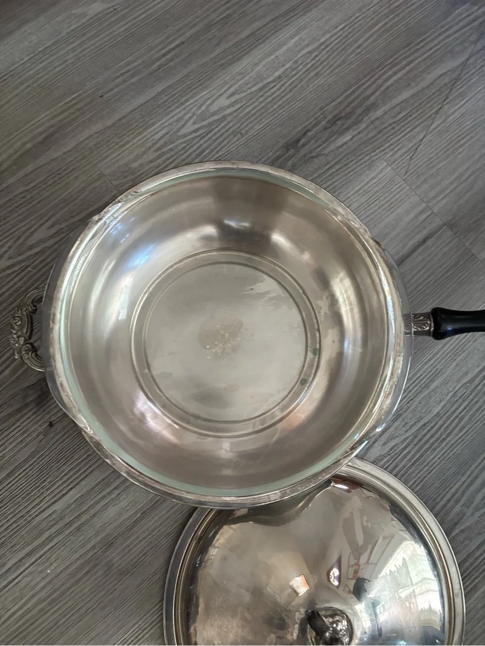 Pyrex glass insert inside a covered silver-plated pot with lid. Used